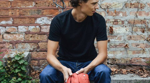 Ryan crouching against an old brick wall.