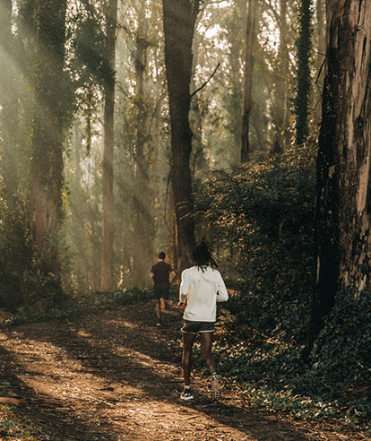 Two men running in the forested woods of the Marin Headlands