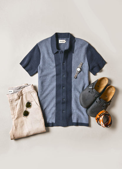 The Button Down Polo in Marine Seed Stitch next to The Sheffield Trouser in Natural Linen and birkenstocks