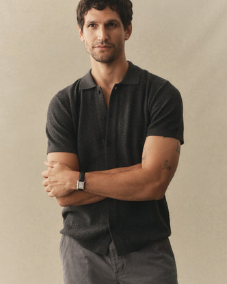 fit model posing in The Button Down Polo in Charcoal Herringbone