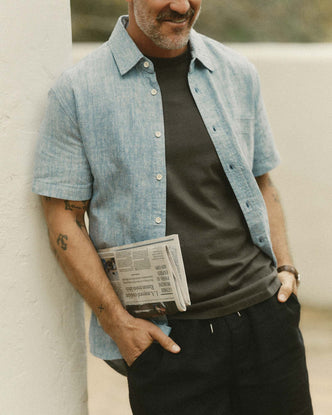 fit model leaning against the wall wearing The Short Sleeve California in Sky Hemp