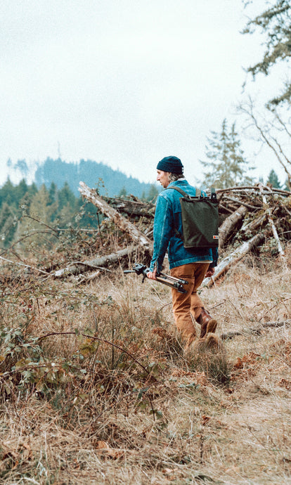 Zach hiking in the woods around the Oregon Coast wearing The Ojai Jacket in Sawyer Wash and The Chore Pant in Tobacco Boss Duck.