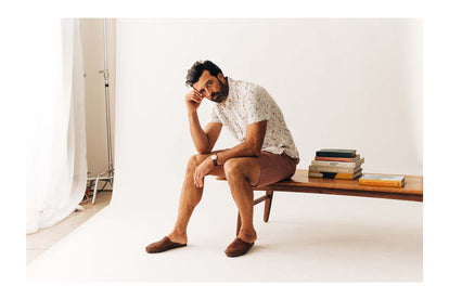 fit model sitting wearing The Apres Short in Fired Brick Dobby