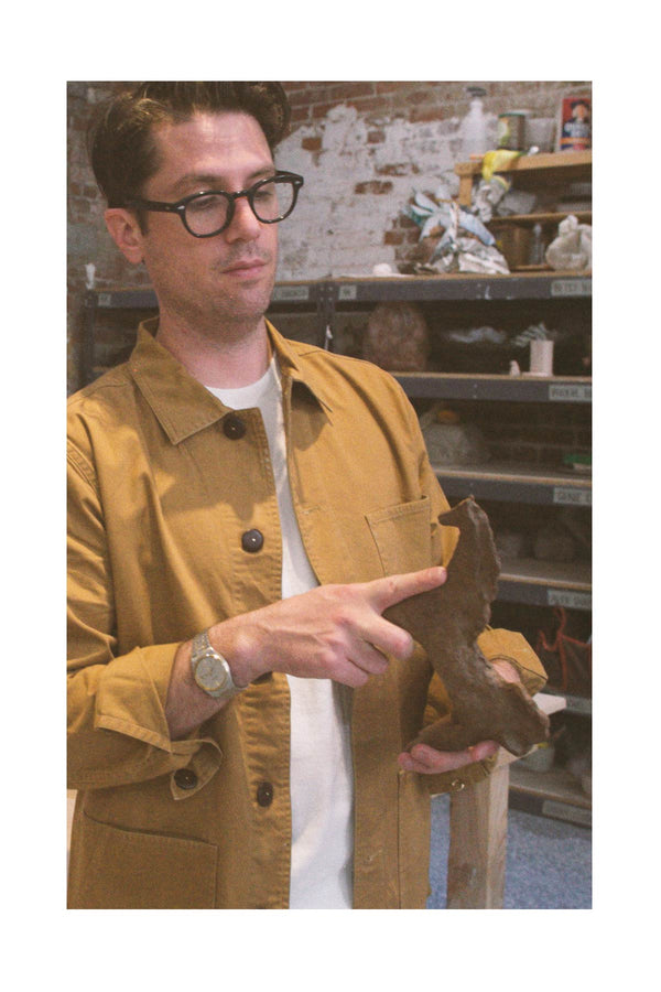 Brian Manger holding his artwork, a ceramic horse.