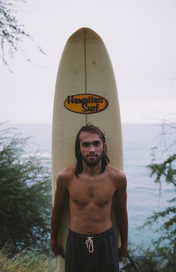 A surfer posing with his