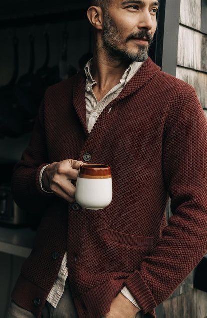 fit model holding a mug wearing The Crawford Sweater in Black Cherry