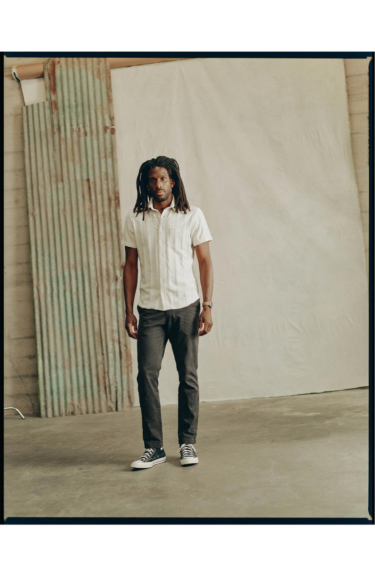 fit model standing on a road wearing The Short Sleeve California in Heather Ash Pointelle Stripe