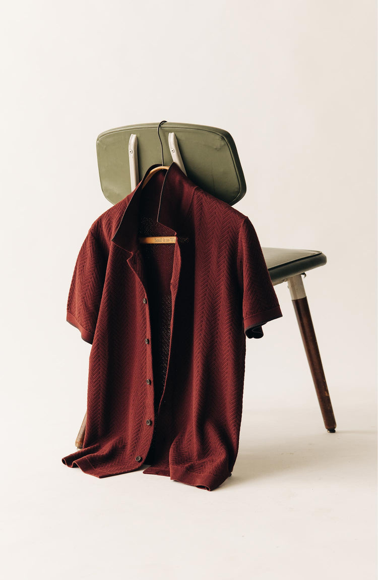 editorial image of The Button Down Polo in Dried Cherry Herringbone on a chair