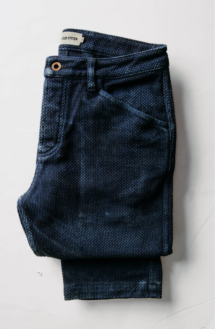 fit model leaning against the wall wearing The Camp Pant in Rigid Indigo Sashiko