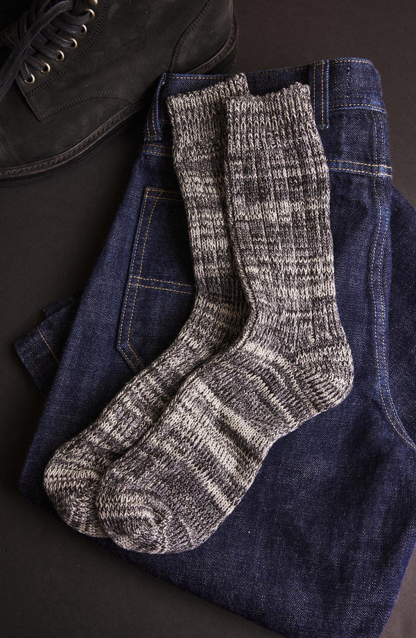 editorial flatlay of The Camp Sock in Marled Blue on a pair of jeans