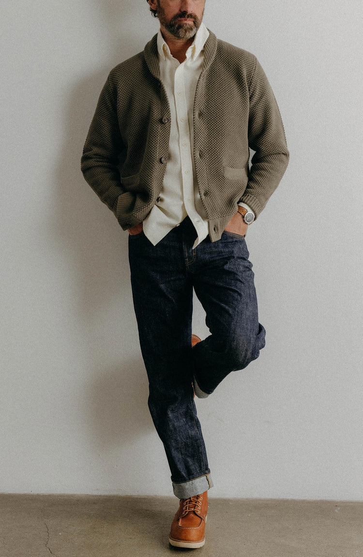 fit model sitting wearing The Crawford Sweater in Fatigue Olive