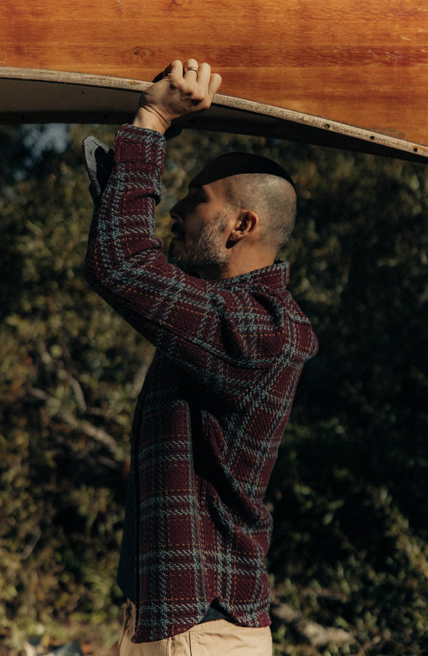 fit model holding a boat wearing The Cutter Overshirt in Port Plaid