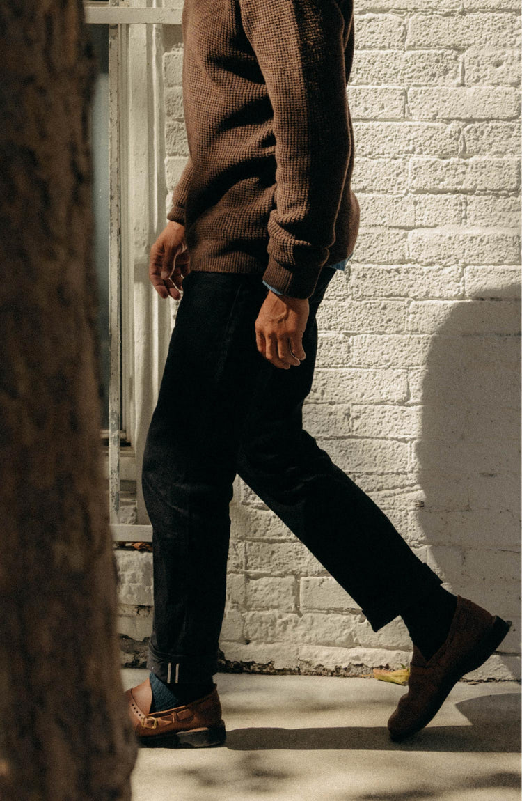 fit model standing wearing The Democratic Jean in Rigid Black Organic Selvedge