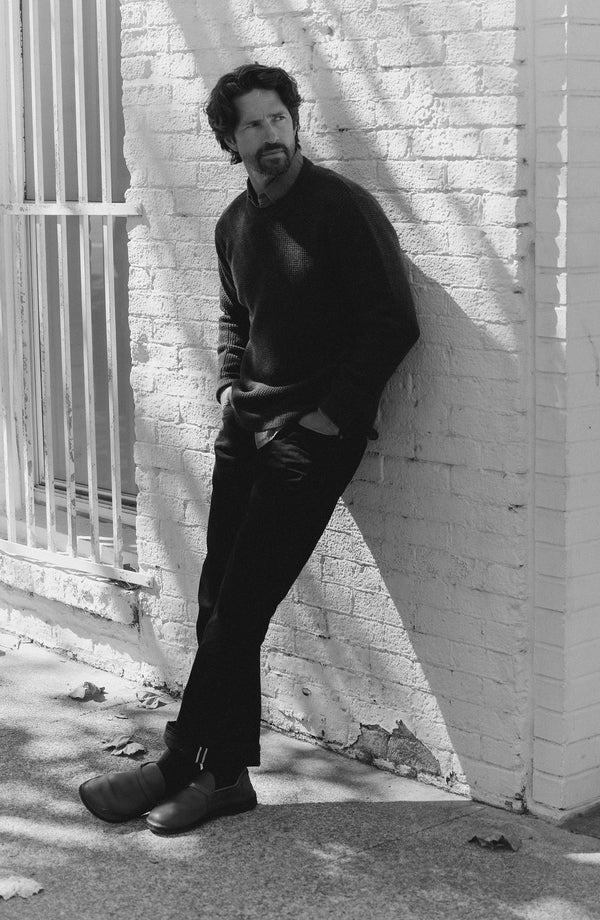 fit model with his hand on his hip wearing The Democratic Jean in Rigid Black Organic Selvedge