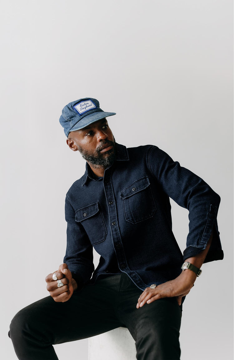 fit model sitting wearing The Division Shirt in Rinsed Indigo