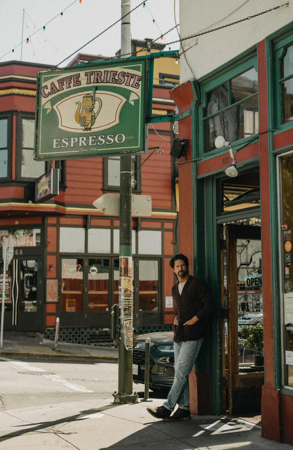 fit model leaning against the wall wearing The Eastmoor Cardigan in Heather Port Wool