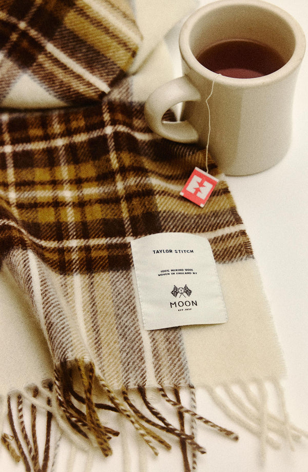 editorial flatlay of The Fireside Scarf in Butterscotch Plaid next to a cup of tea
