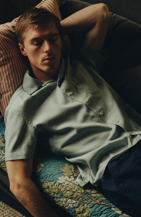 fit model on a couch wearing The Hawthorne Shirt in Surf Green
