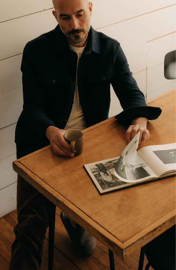 fit model sitting wearing The Maritime Shirt Jacket in Dark Navy Moleskin Twill