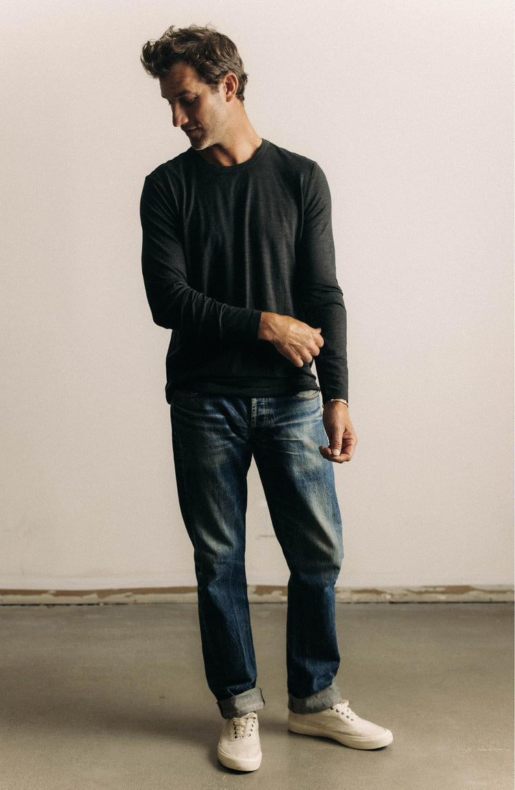 fit model posing in The Merino Long Sleeve Tee in Heather Black