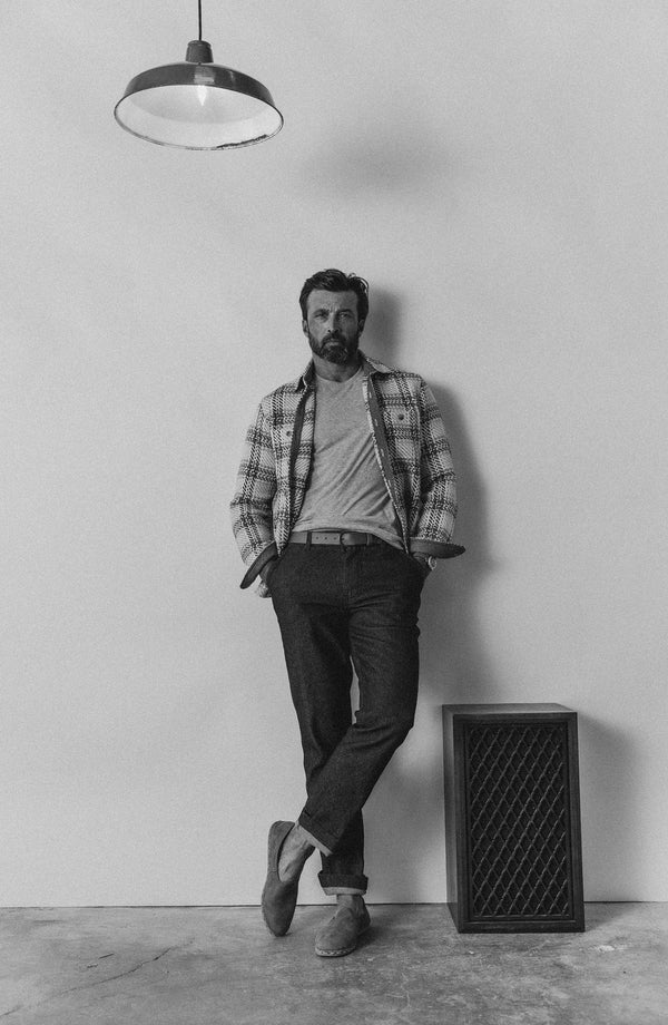 fit model leaning against the wall wearing The Morse Pant in Rinsed Indigo Twill