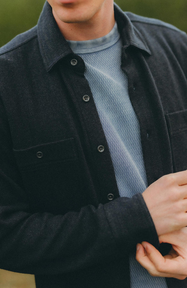 fit model adjusting the cuffs on The North Shore Knit Shirt in Heather Navy