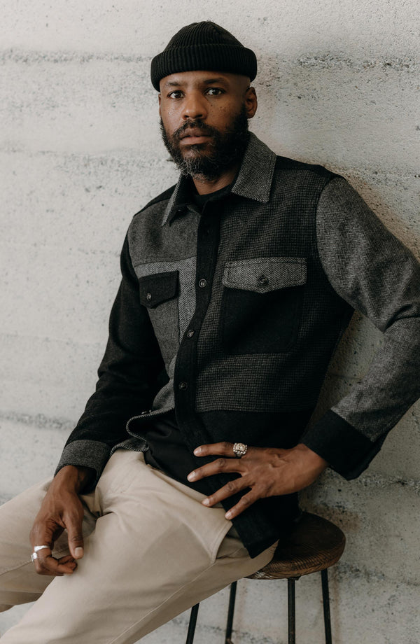 fit model sitting wearing The Patchwork Overshirt in Ash Tweed