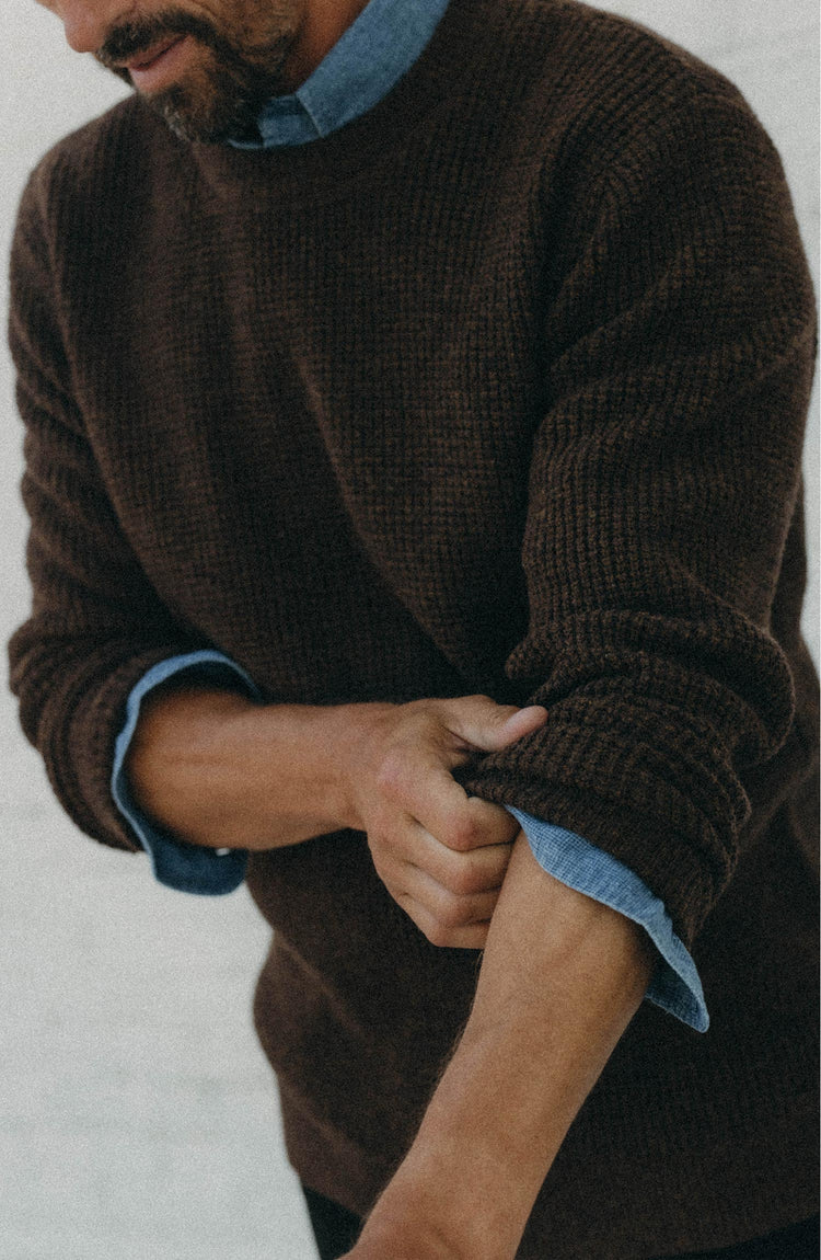 fit model adjusting the sleeves on The Sidecountry Crew in Heather Marsh Merino Waffle