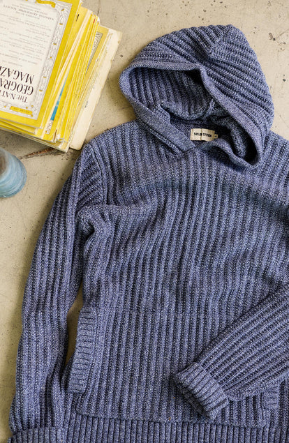 material shot of the The Bryan Pullover Sweater in Blue Melange next to a pile of books