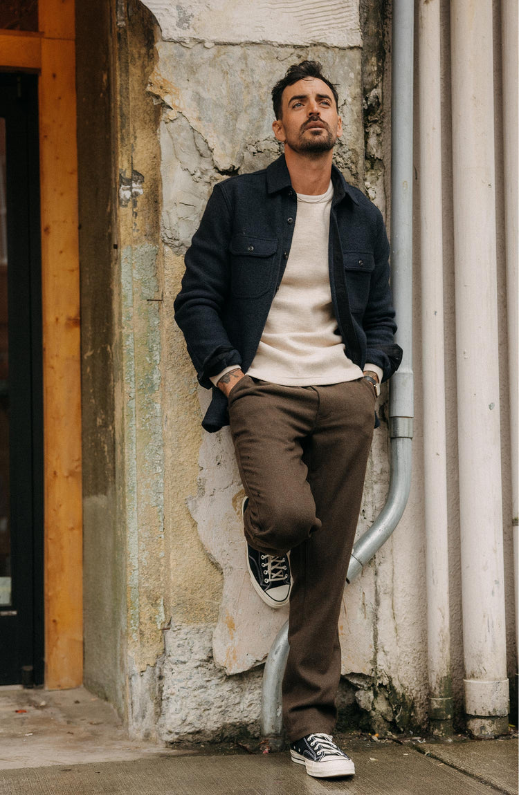 fit model leaning against the wall wearing The Connor Overshirt in Dark Navy Boucle