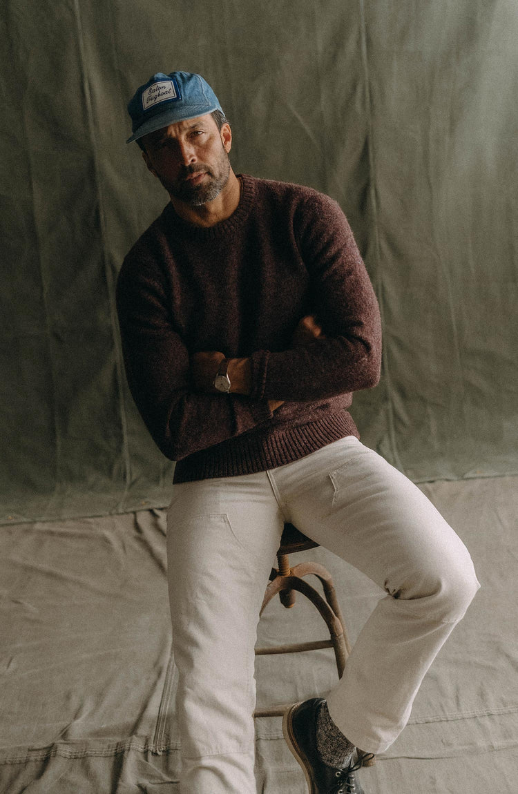 fit model sitting wearing The Eastmoor Sweater in Heather Port Wool