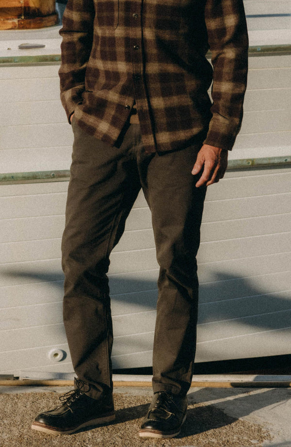 A pair of Foundation Pants folded on a black background, showing the back pocket.