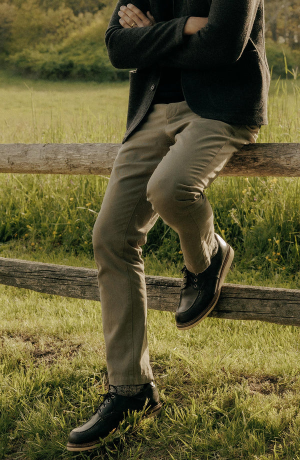 A pair of Foundation Pants folded on a black background, showing the back pocket.