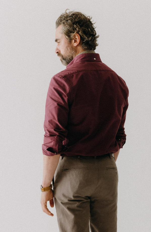A pair of Foundation Pants folded on a black background, showing the back pocket.