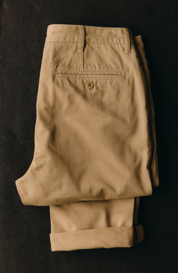 A pair of Foundation Pants folded on a black background, showing the back pocket.
