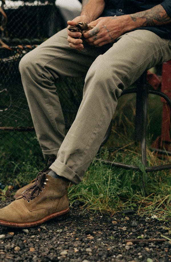 A pair of Foundation Pants folded on a black background, showing the back pocket.