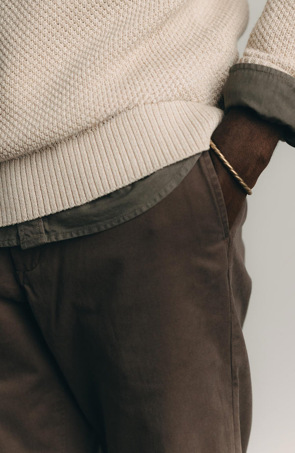 A pair of Foundation Pants folded on a black background, showing the back pocket.