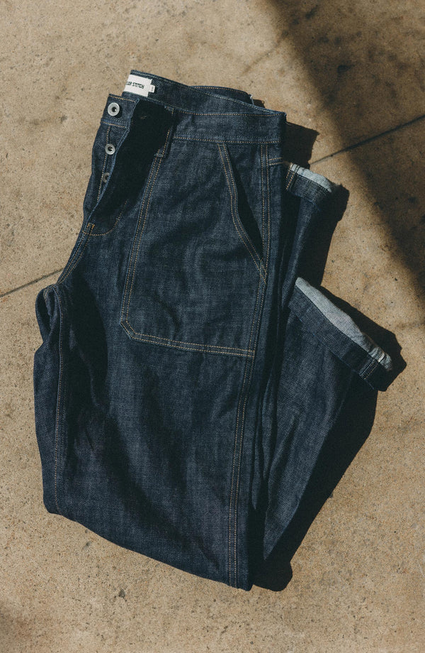 fit model sitting wearing The Mariner Jean in Rinse Organic Selvedge