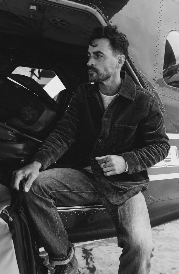 fit model sitting in a seaplane wearing The Ojai Jacket in Bourbon Corduroy