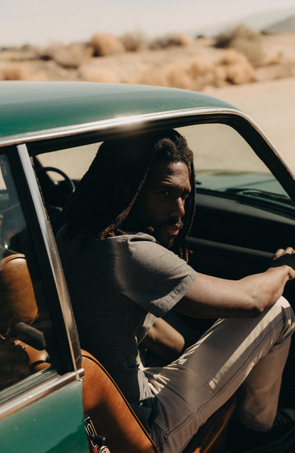 fit model posing in a car wearing The Short Sleeve California in Heather Slate Cord