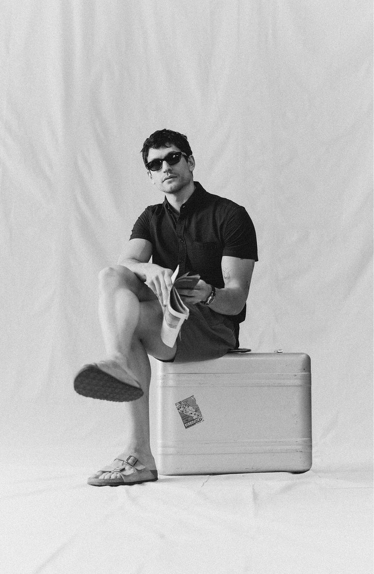fit model putting on sunglasses wearing The Short Sleeve Jack in Faded Black Seersucker