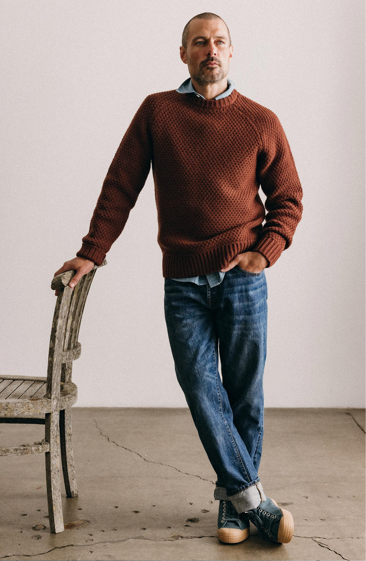 fit model leaning against a chair wearing The Straight Jean in Mid Wash Organic Selvedge