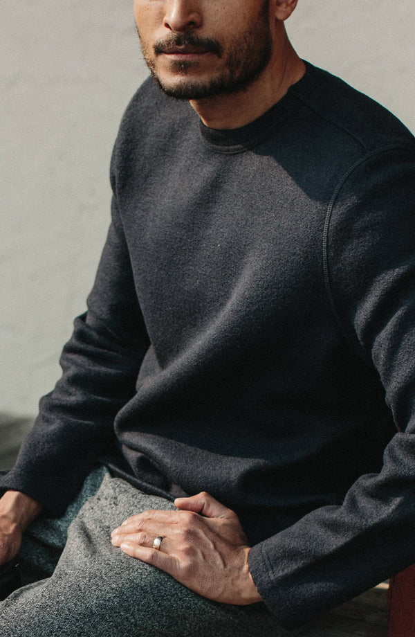 Model wearing The Weekend Crewneck in Navy Boiled Wool sitting down