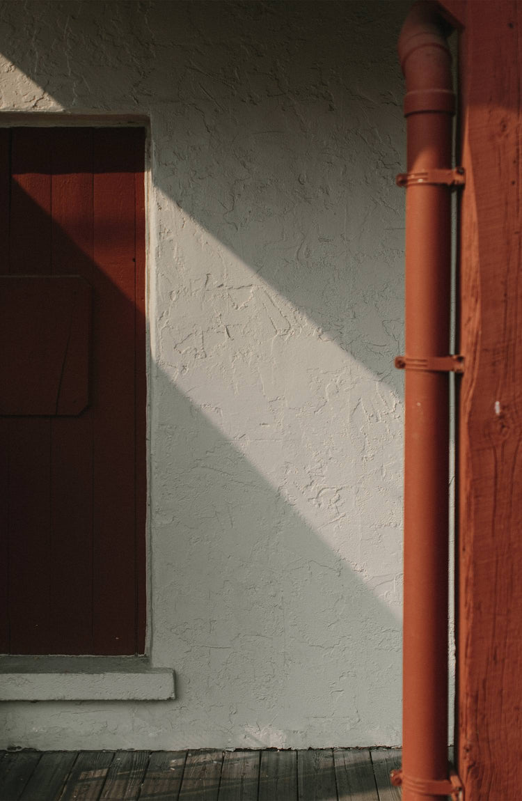 The wall of a barn with a visible pipe