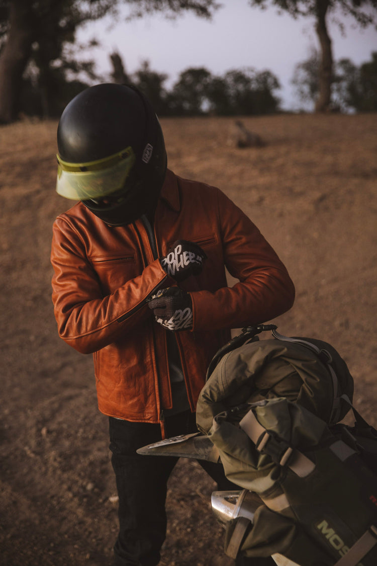 Motorcyclist adjusting the cuffs on his leather jacket