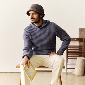 fit model sitting wearing The Bryan Pullover Sweater in Blue Melange
