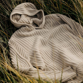 material shot of The Bryan Pullover Sweater in Flax Melange in the grass