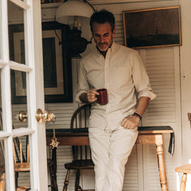 fit model leaning against a wooden desk in The Jack in Sunburn Stripe Oxford