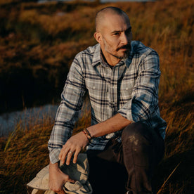 fit model sitting in The Ledge Shirt in Faded Blue Plaid