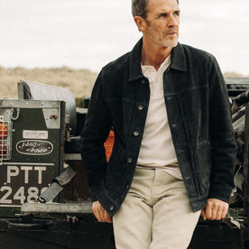 fit model sitting against a jeep in The Ryder Jacket in Dark Navy Suede